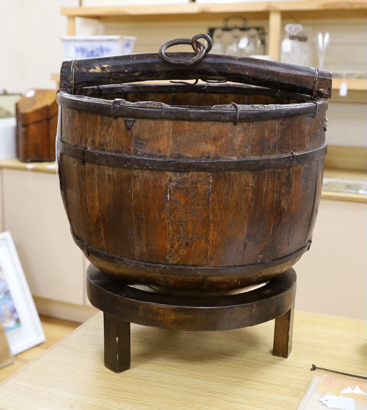 A Chinese wooden water bucket and carrying handle on stand, 55cms including stand